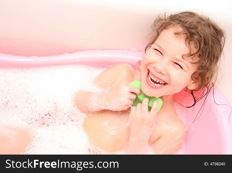 The Small girl bathes in bath. She is merrily. The Small girl bathes in bath. She is merrily.