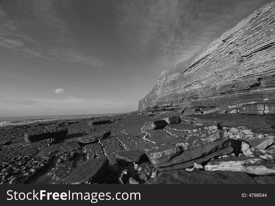 Black and white photograph of a beach and cliffs. Black and white photograph of a beach and cliffs