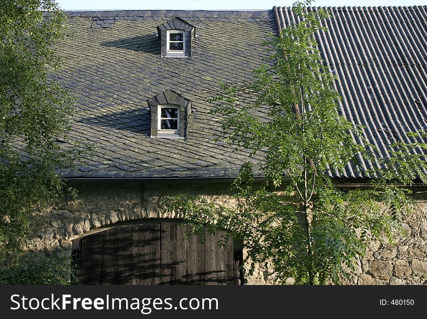 The front of a barn with trees