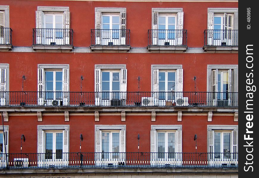 Grid of windows over a red wall. outdoors in Madrid. Grid of windows over a red wall. outdoors in Madrid