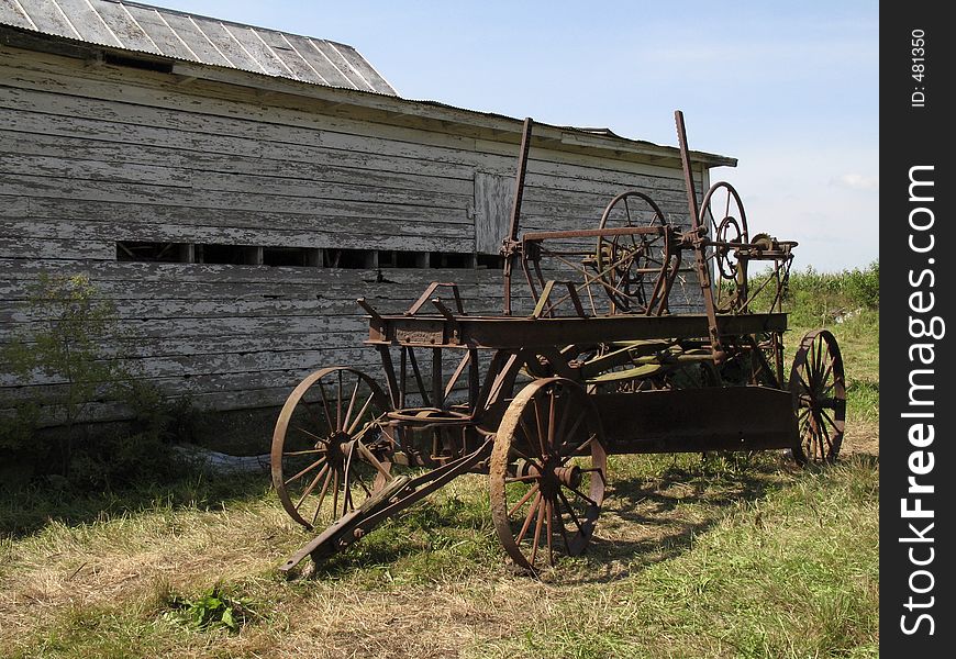 Rusted vintage wagon near an old barn