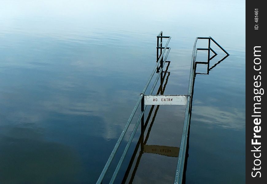 A pathway submerged in water, with a NO ENTRY sign. A pathway submerged in water, with a NO ENTRY sign