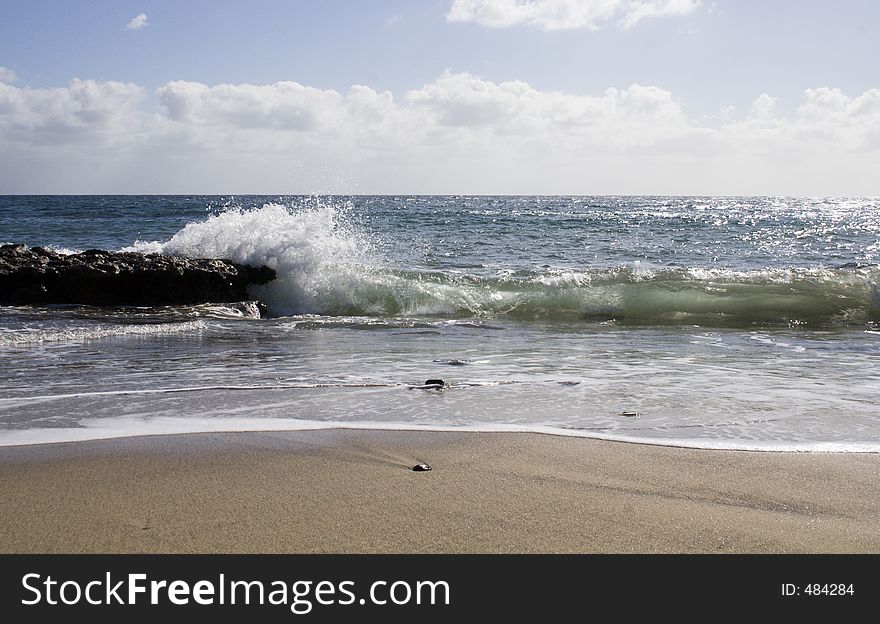 Spray of a wave breaking on a rocky beach. Spray of a wave breaking on a rocky beach.