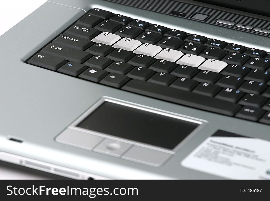 Close up of portion of a silver and black laptop with the keys, ï¿½QWERTYï¿½ highlighted. Close up of portion of a silver and black laptop with the keys, ï¿½QWERTYï¿½ highlighted