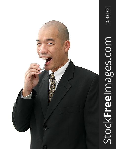 Oriental man in suit eating something square or rectangular in shape. Oriental man in suit eating something square or rectangular in shape