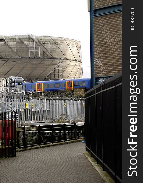 A South London view showing a Gasometer, power transformers, canal, footpath and overground train. A South London view showing a Gasometer, power transformers, canal, footpath and overground train