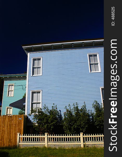 BLUE HOUSE,BLUE SKY, WHITE WICKER FENCE
