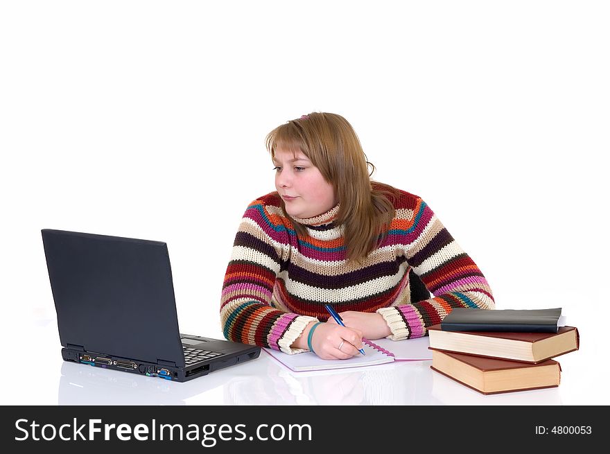 Teenage student girl doing schoolwork with laptop and books at desk, white background, reflective surface, studio shot,. Teenage student girl doing schoolwork with laptop and books at desk, white background, reflective surface, studio shot,