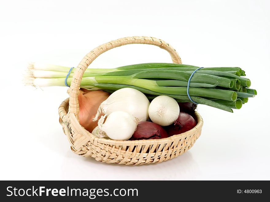 Different sorts of onions in a basket on bright background. Different sorts of onions in a basket on bright background