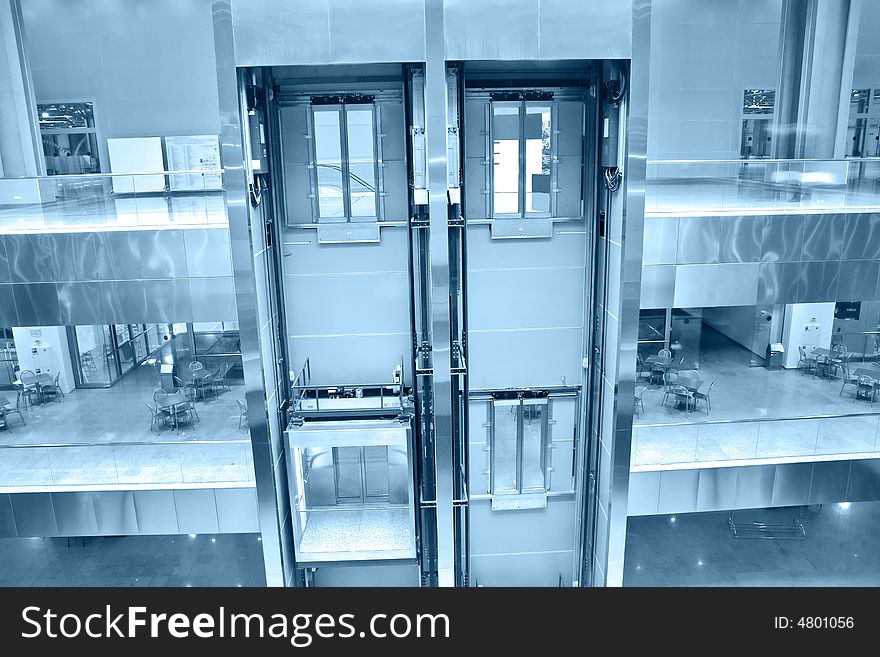 Lifts in office building toned blue
