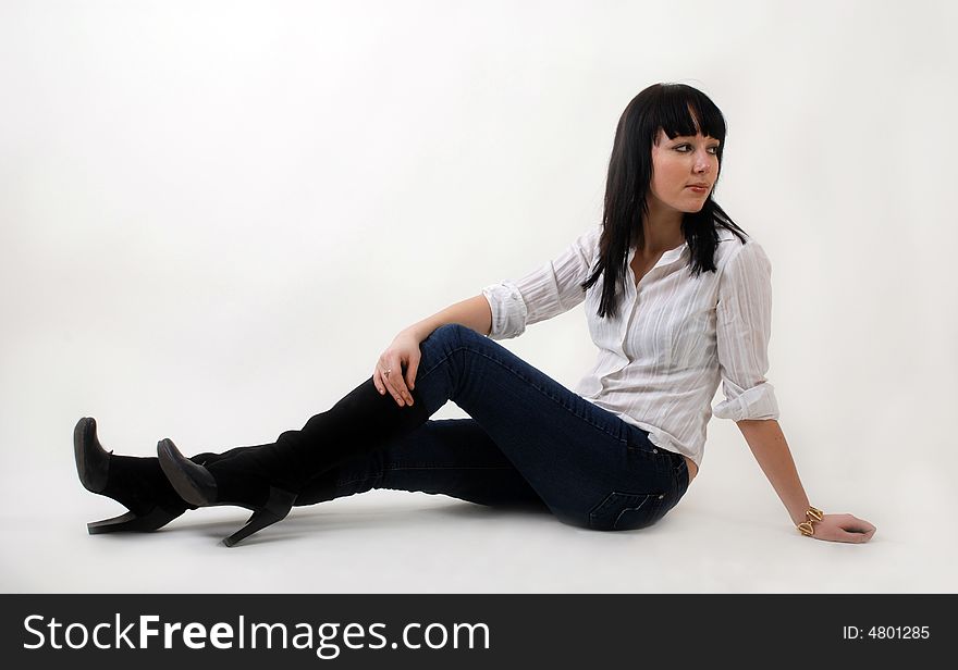 Young beautiful woman in casual clothes sitting on white background. Young beautiful woman in casual clothes sitting on white background