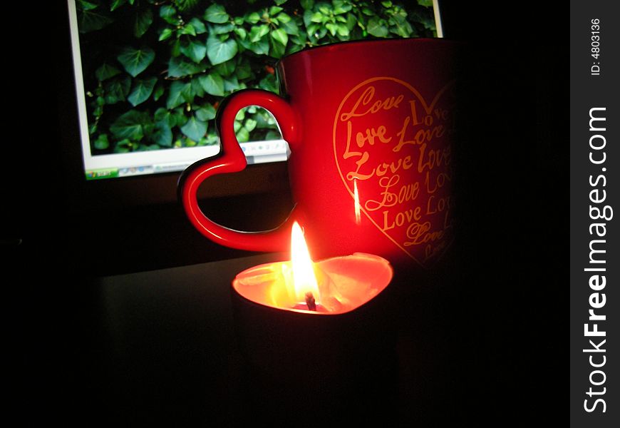 Cup of coffe - heart candle and monitor on black background. Cup of coffe - heart candle and monitor on black background