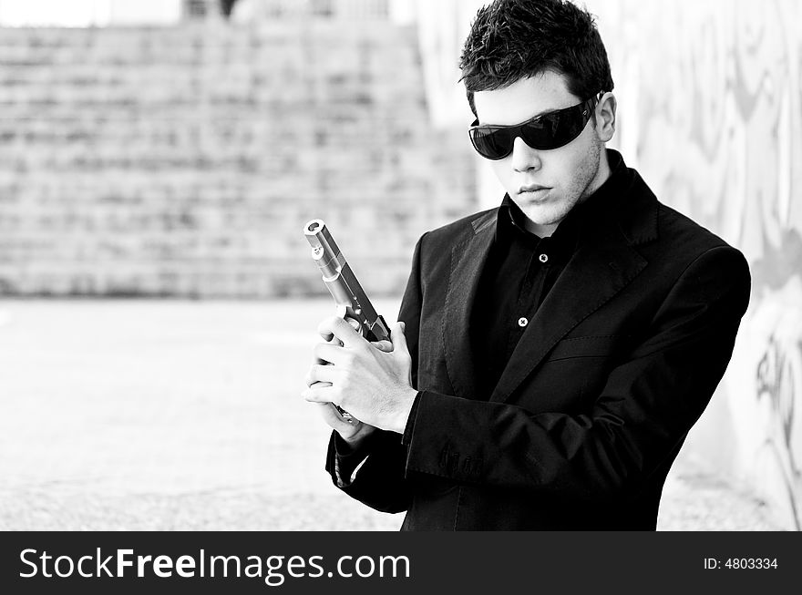 Male model performing secret agent with gun. Male model performing secret agent with gun