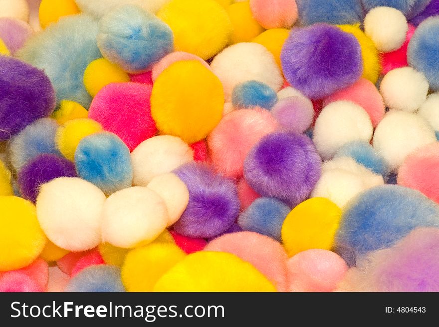 A view of an assortment of cotton balls of different sizes and bright colors. A view of an assortment of cotton balls of different sizes and bright colors.