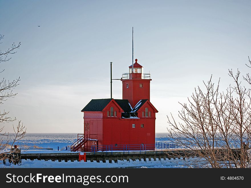 Bright red lighthouse in the frozen harbor.