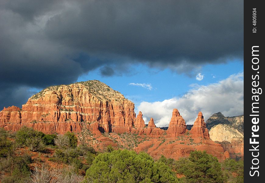 Red rocks of Sedona in the sun with black clouds rolling in. Red rocks of Sedona in the sun with black clouds rolling in.