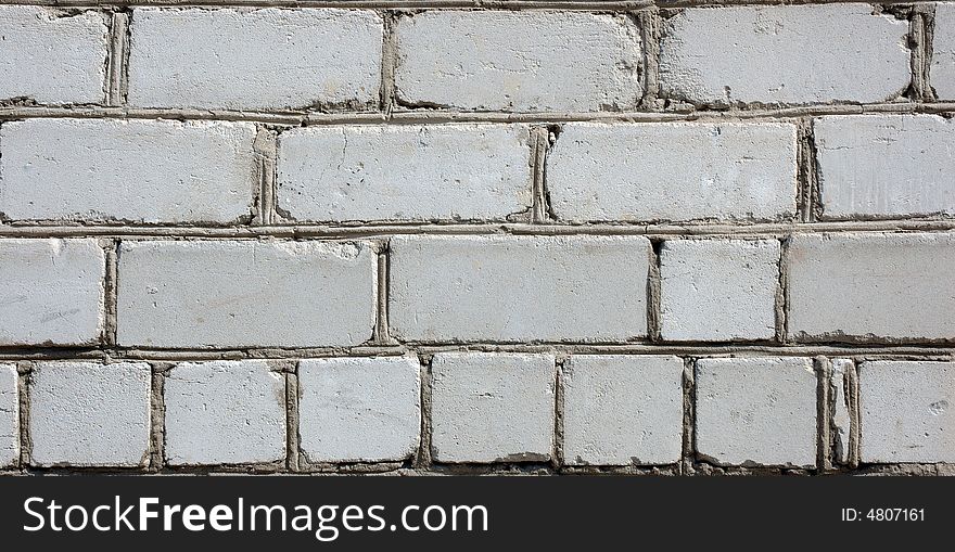 Old gray brick wall. White (in past) silicate bricks like background.