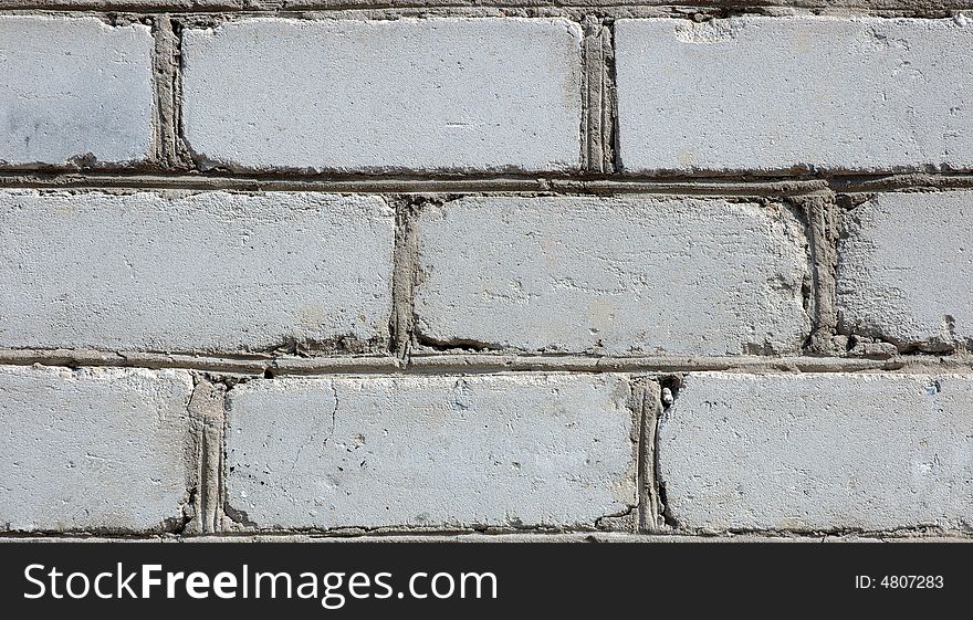 Old gray brick wall. White (in past) silicate bricks like background.