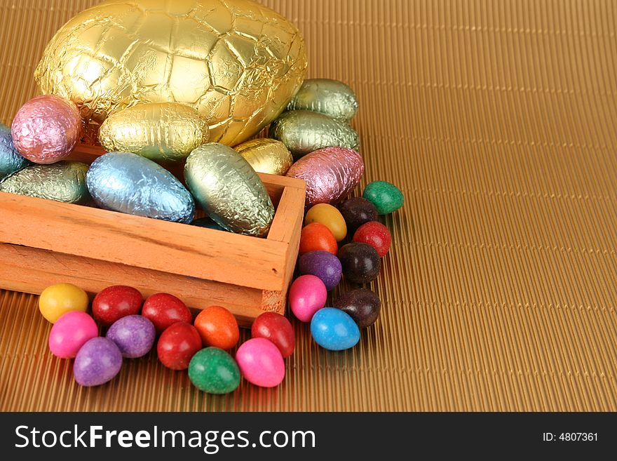 Various colors and shaped easter eggs on a gold background