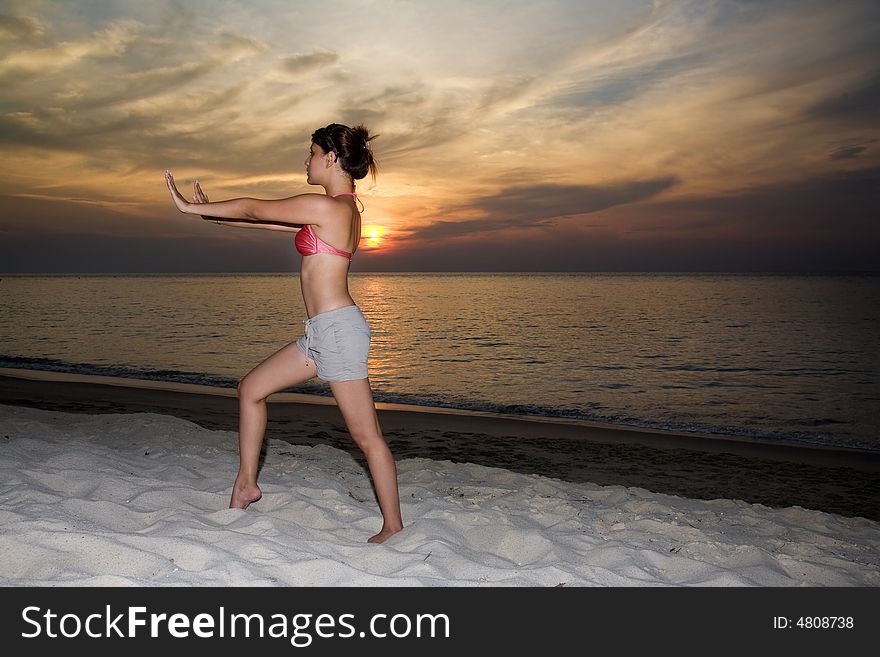 Woman doing yoga exercise by the sunset beach. Woman doing yoga exercise by the sunset beach