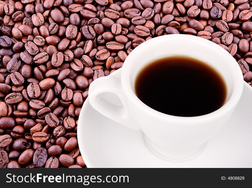 White cup of coffee over coffee beans background