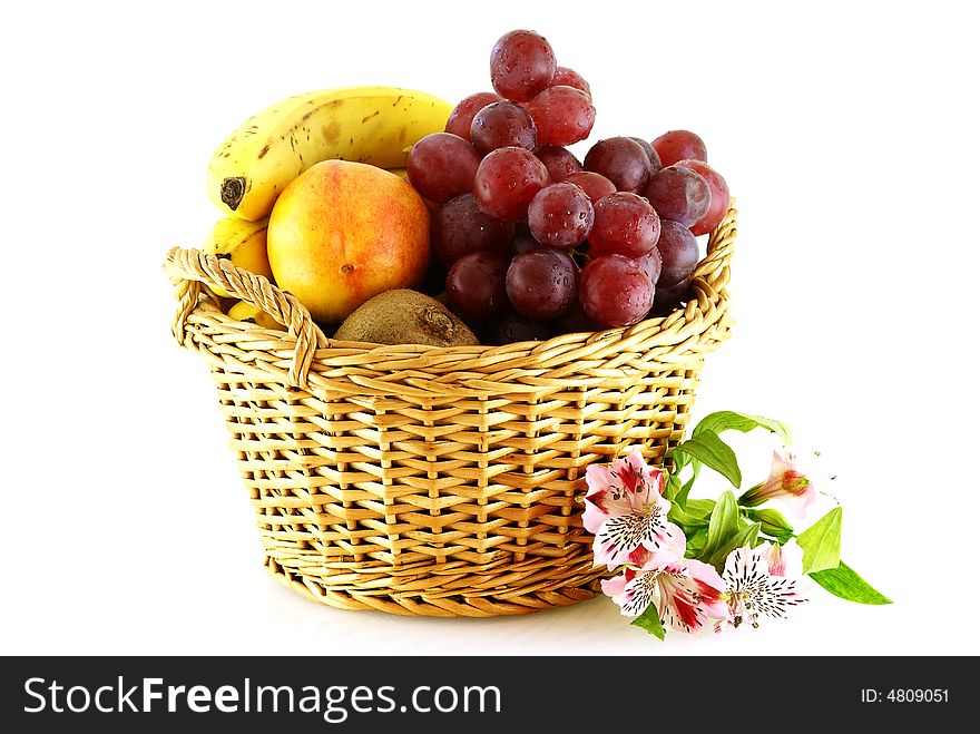 Various of fruits in a basket with a flower over white