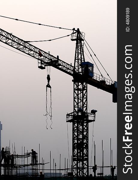 Worker on roof and crane on construction site. Worker on roof and crane on construction site.