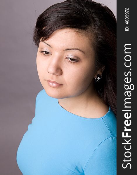 Multi-ethnic girl in studio on grey background.