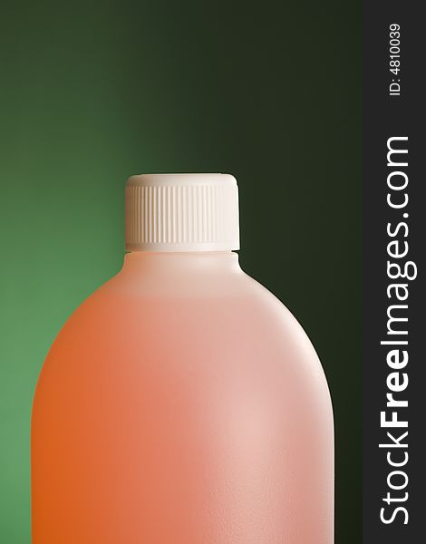 Plastic chemical bottle over a green background