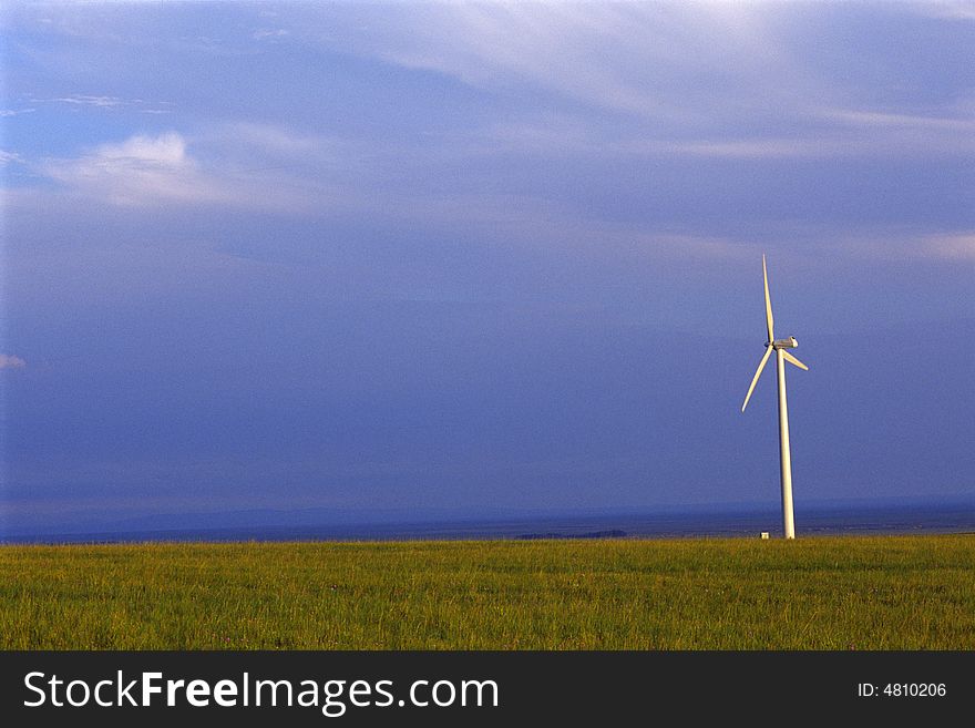 Wind turbine silhouette in meadow