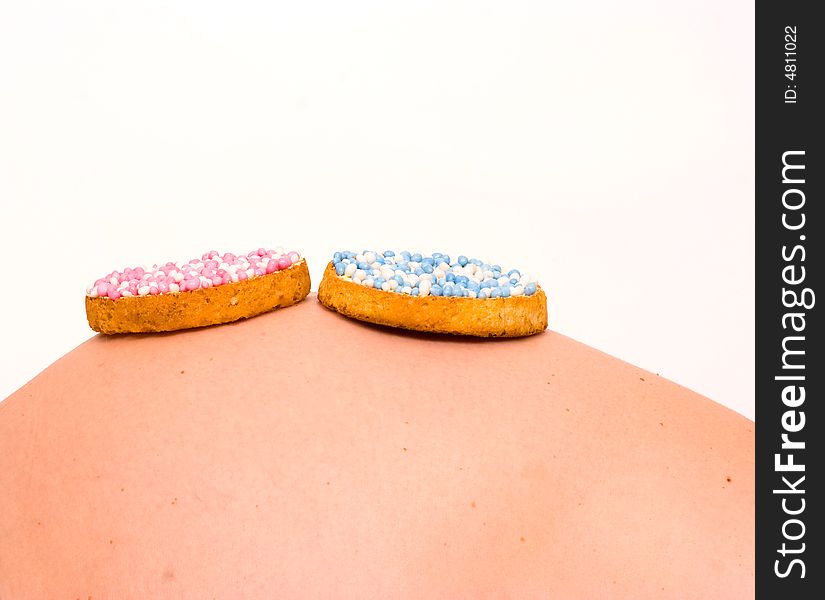 A biscuit with blue and pink candy on pregnant stomach. What will it be?