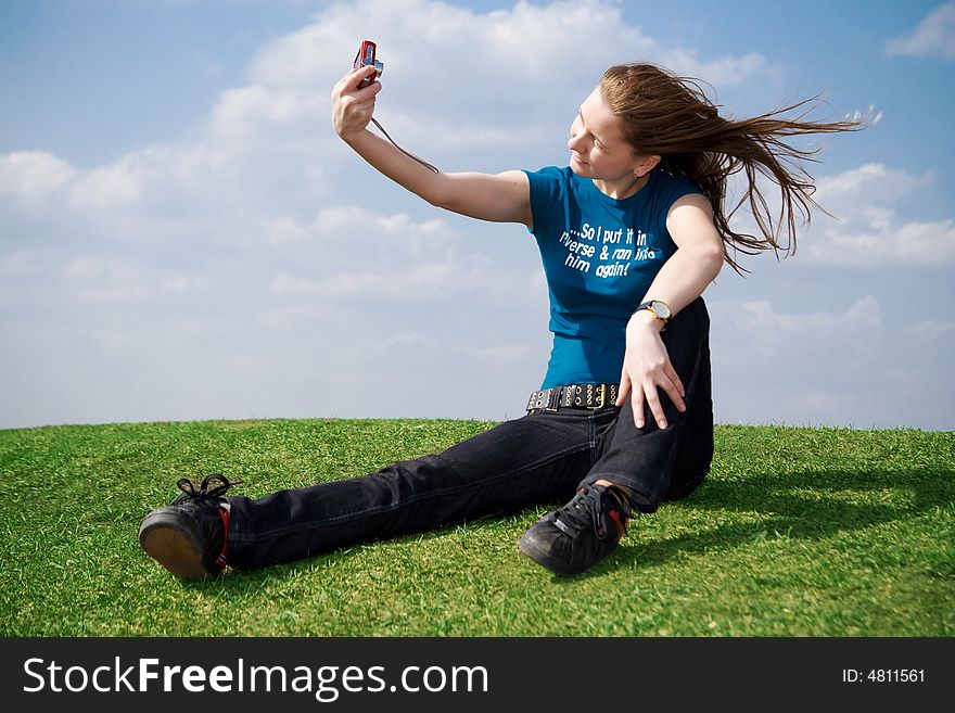 The girl with the camera on a background of the blue sky