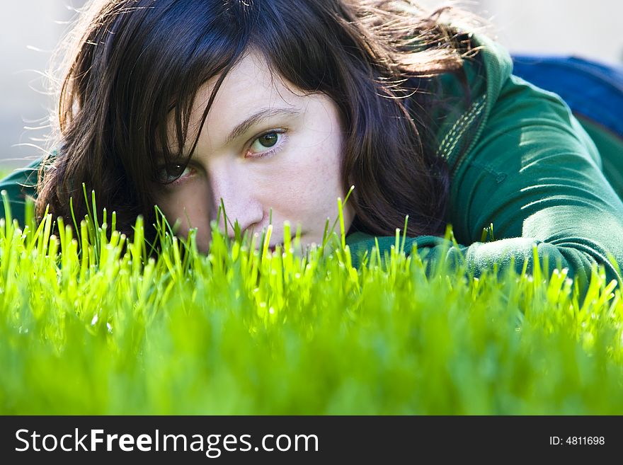 Young woman staring at camera in the grass. Young woman staring at camera in the grass.