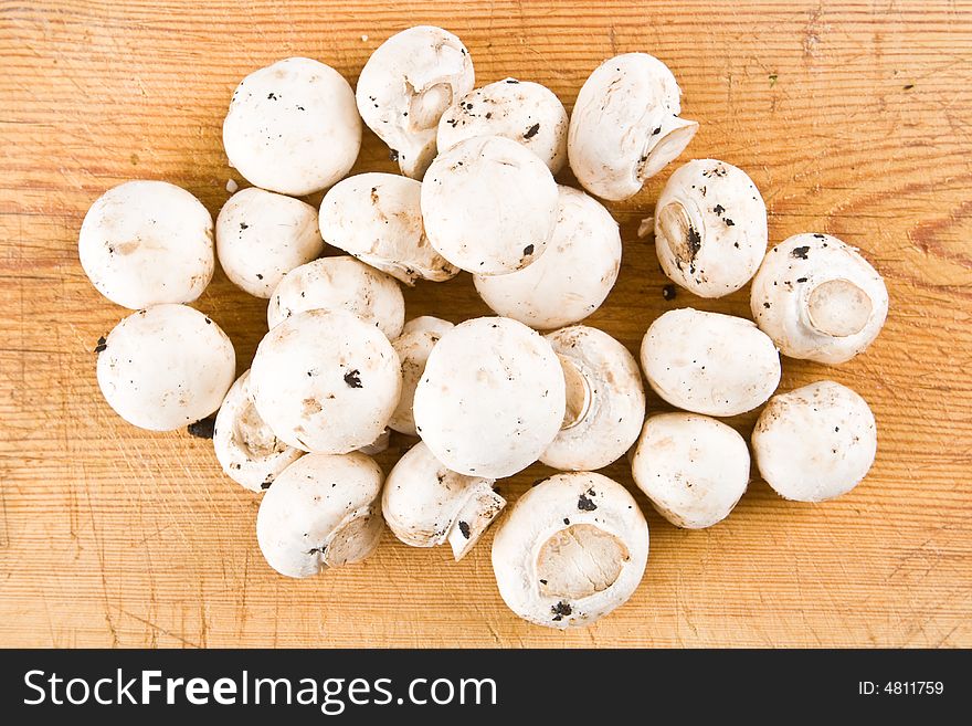 Fresh unwashed mushrooms on a wooden board