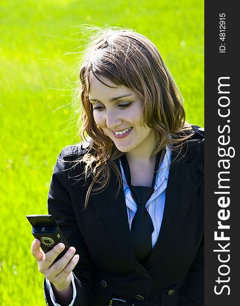 Businesswoman at phone, sending text message on spring background