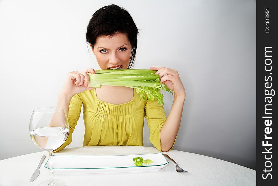 Young woman having her breakfast with water and celery