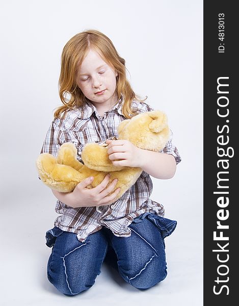 Happy girl is taking care of her yellow teddy bear