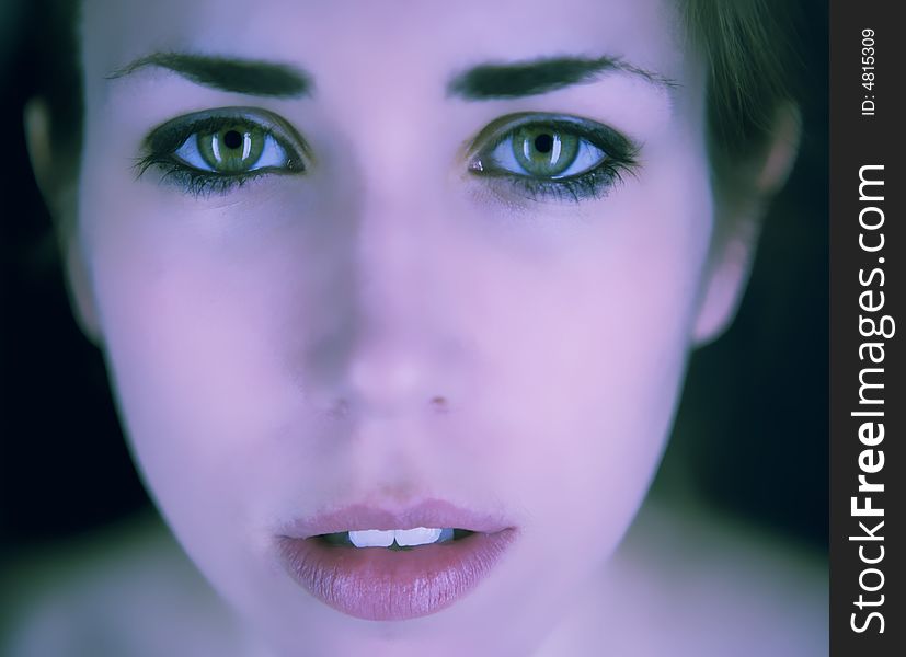A close up photo of a face of an attractive young woman with green eyes. A close up photo of a face of an attractive young woman with green eyes