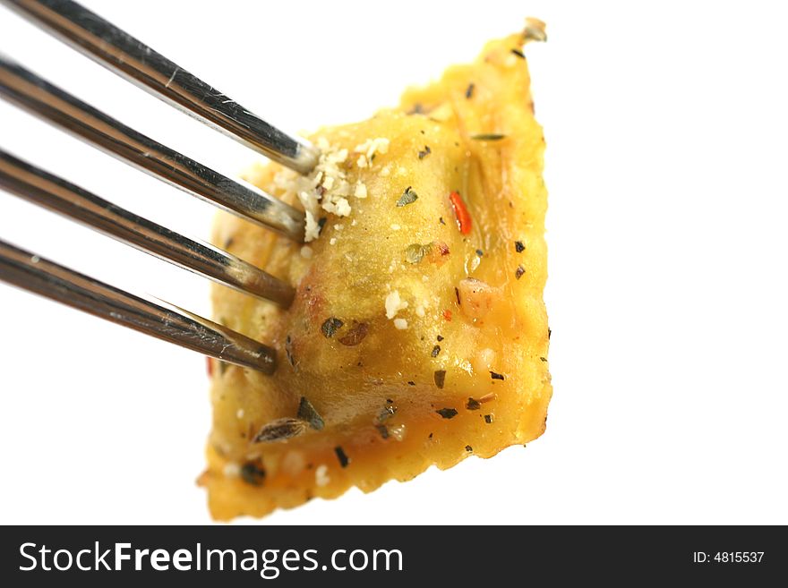 Closeup of cooked ravioli on a fork isolated on a white background