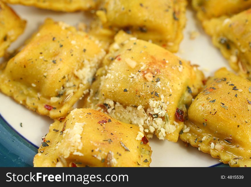 Closeup of cooked ravioli with spices on a plate. Closeup of cooked ravioli with spices on a plate