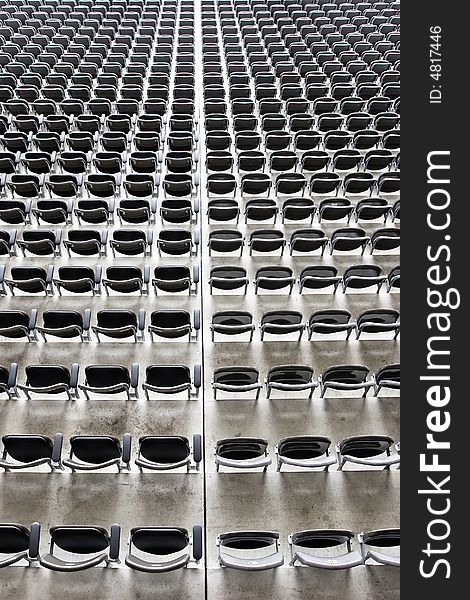 Rows and rows of empty grey seating at an event. Rows and rows of empty grey seating at an event