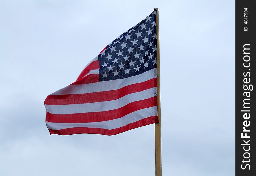 The flag of the USA on the background of the blue sky