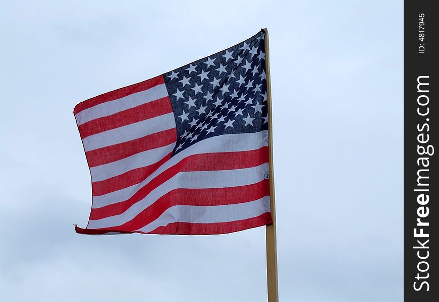 The flag of the USA on the background of the blue sky