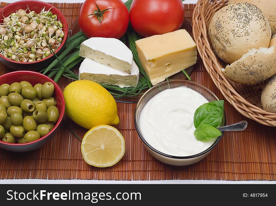 Delicious breakfast: rolls, cheese, camembert, joghurt, tomatoes, sprouts, olives and lemons. Delicious breakfast: rolls, cheese, camembert, joghurt, tomatoes, sprouts, olives and lemons.