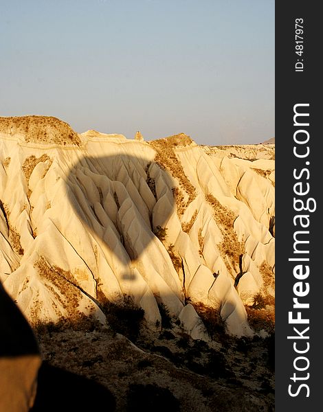 Shadow of balloon drifting across rock formation in cappadocia. Shadow of balloon drifting across rock formation in cappadocia