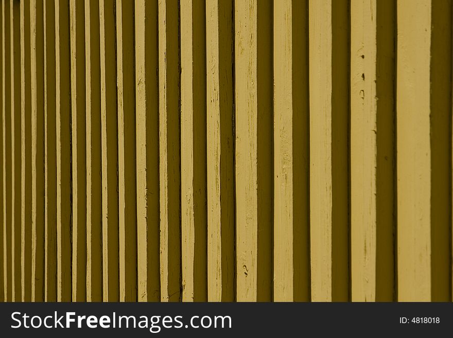 Detail of a mustard yellow wooden slatted wall. Detail of a mustard yellow wooden slatted wall