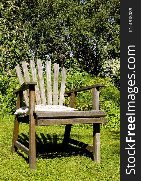 A wooden garden chair on a sunny summer lawn