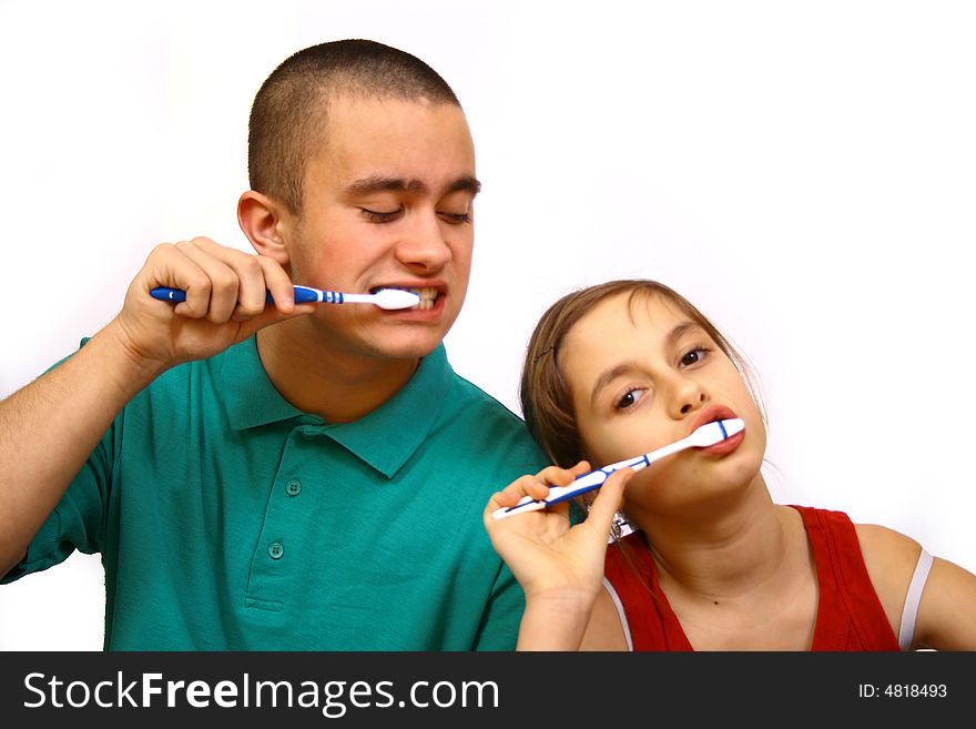 Brother and sister clean a teeth.