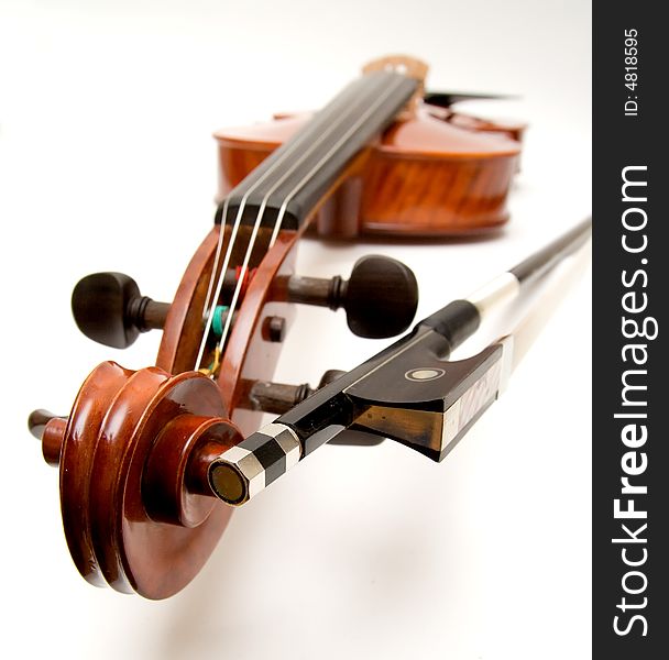 A violin and bow with the focus on the scroll and button of the bow.