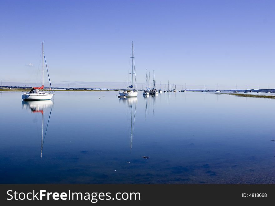 A line of yachts moored in Keyhaven waters, England. A line of yachts moored in Keyhaven waters, England